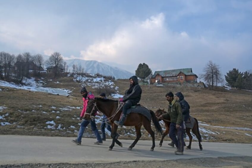 Guides lead visitors past ski slopes usually covered in snow but now bare, a stark example of the impacts of the extreme weather caused by the rapidly heating planet