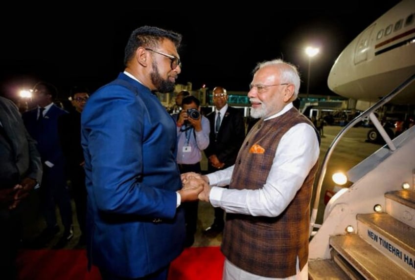 India's Prime Minister Narendra Modi (R) was welcomed by Guyana's President Irfaan Ali upo