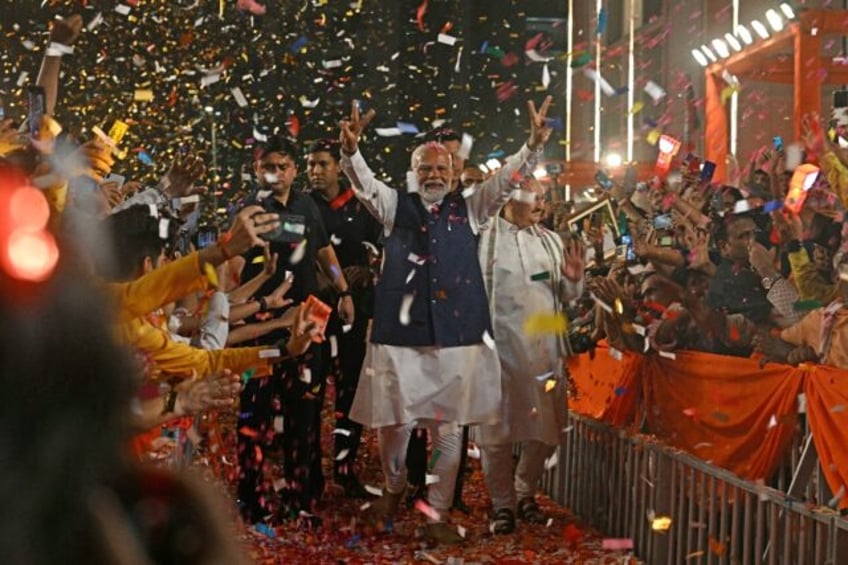 Modi flashes victory signs as he arrives at his BJP party's headquarters