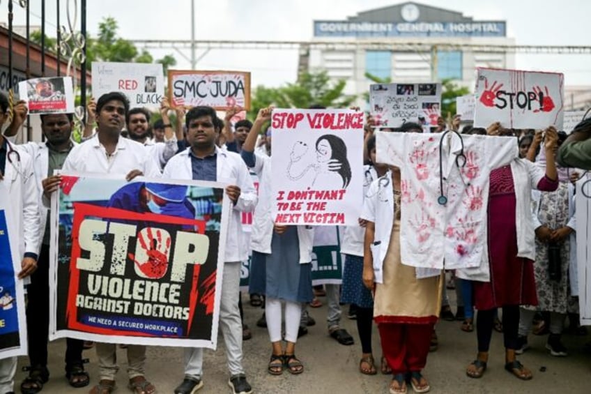 Doctors hold posters to protest the rape and murder of a young medic from Kolkata