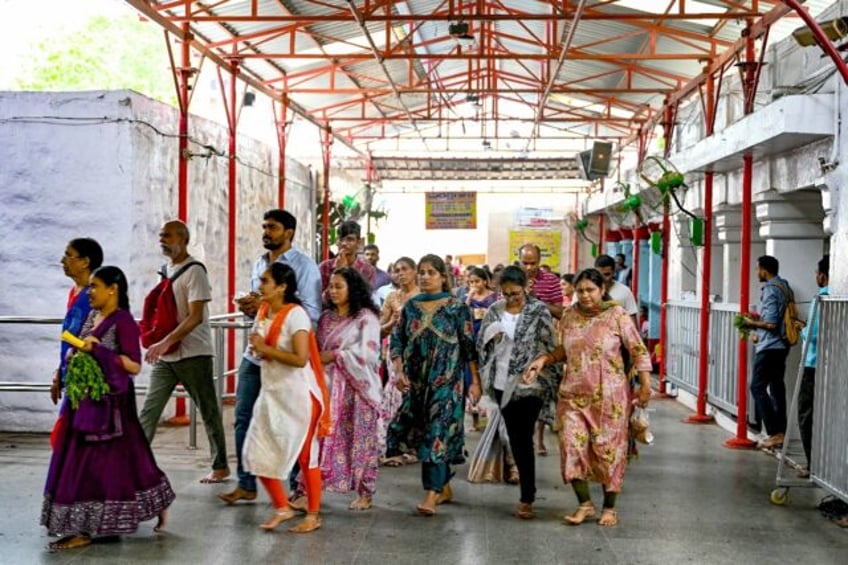 Hindu devotees walk around the inner chamber of Chilkur Balaji temple near Hyderabad, man