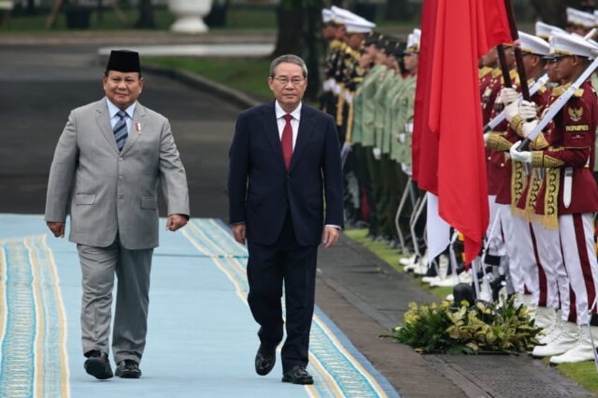Indonesia's President Prabowo Subianto (L) and Chinese Premier Li Qiang inspect a guard of