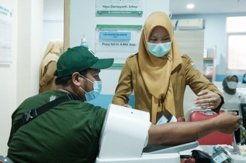 A man gets his blood pressure measured before a doctor's consultation at a community healt