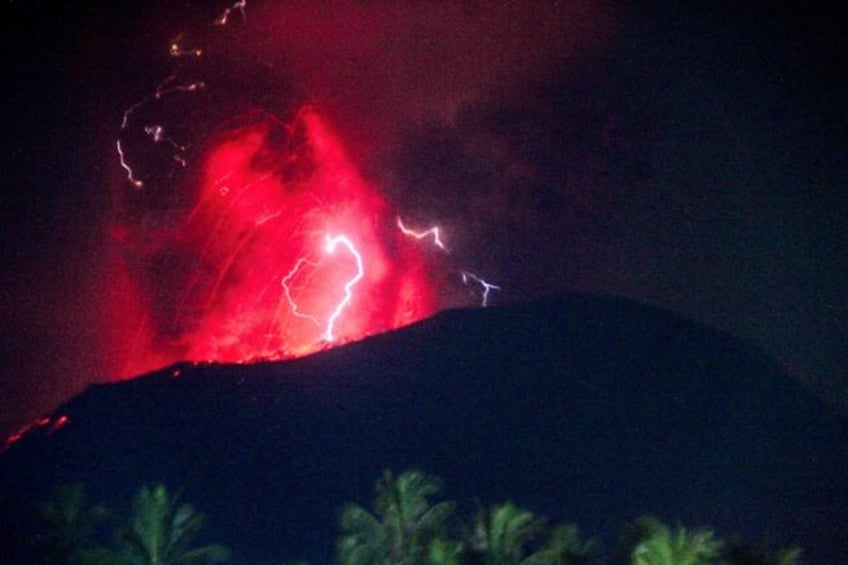 Lightning strikes as lava erupts from the crater of Mount Ibu, as seen from West Halmahera