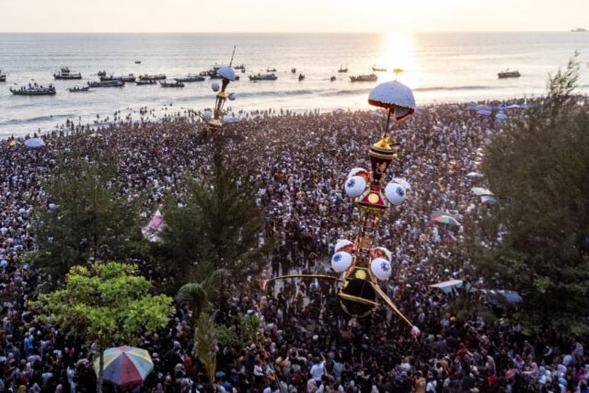 Thousands flock to the coast of western Indonesia to watch two mythical effegies cast into