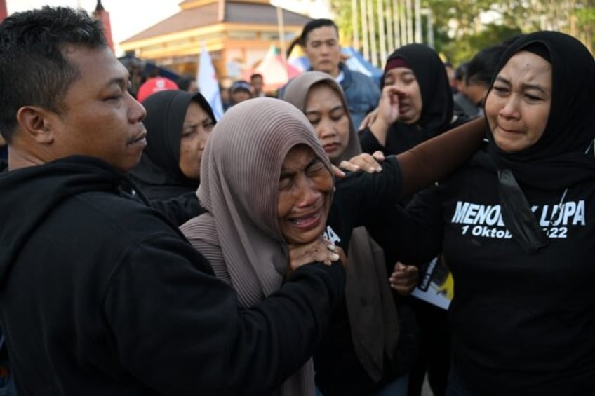 indonesians pay tribute to victims of stadium crush fires set on pitch