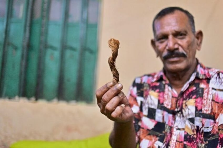 Former hangman Shahjahan Bouya proudly shows visitors a small piece of the rope -- one cor