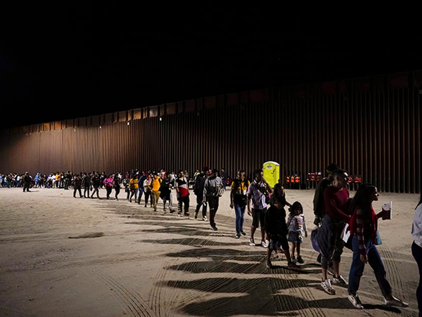 Migrants board a bus after crossing into the United States near the end of a border wall Tuesday, Aug. 23, 2022, near Yuma, Ariz. A border wall with Mexico isn't the issue it was during Donald Trump's presidency but plans for more barriers in Yuma, Ariz., is a reminder of …