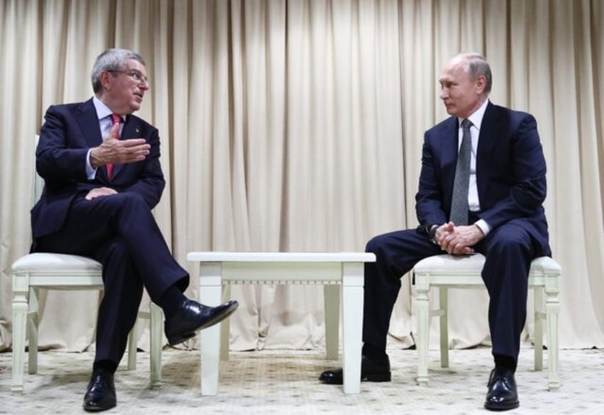 Russian President Vladimir Putin listens to International Olympic Committee (IOC) presiden