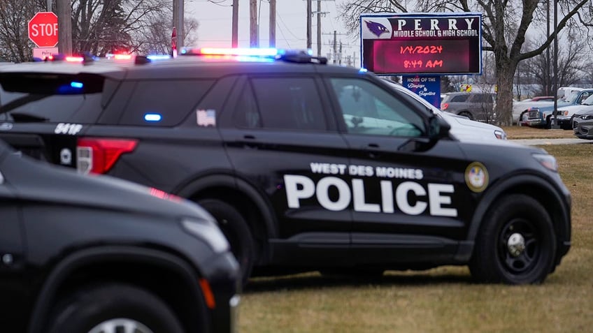 Police vehicles are parked outside Perry High School