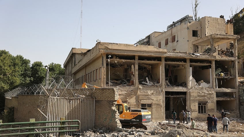 people standing outside destroyed Evin prison