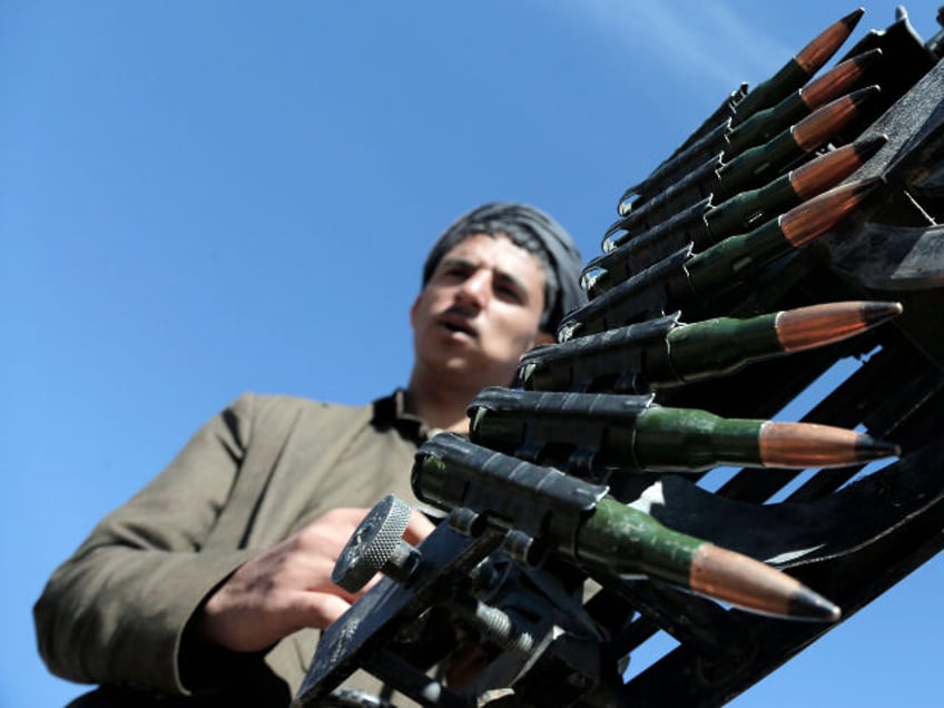 A Houthi fighter manning a machine gun mounted on a vehicle during a tribal parade held ag