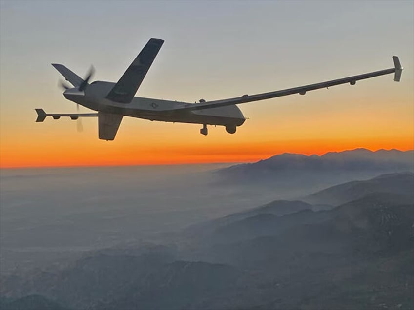 An MQ-9 Reaper remotely piloted aircraft flies above the smoky San Gabriel Mountains of so