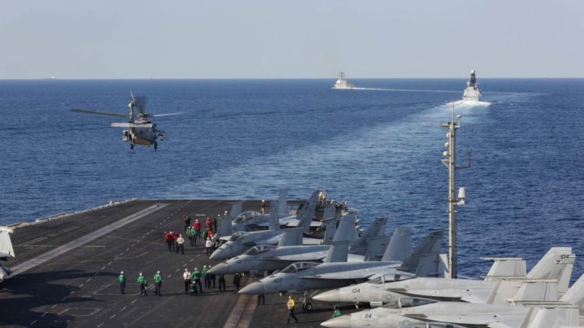  In this handout photo provided by the US Navy, The aircraft carrier USS Abraham Lincoln (CVN 72) transits the Strait of Hormuz as an MH-60S Sea Hawk helicopter from the Nightdippers of Helicopter Sea Combat Squadron (HSC) 5 lifts off from the flight deck.