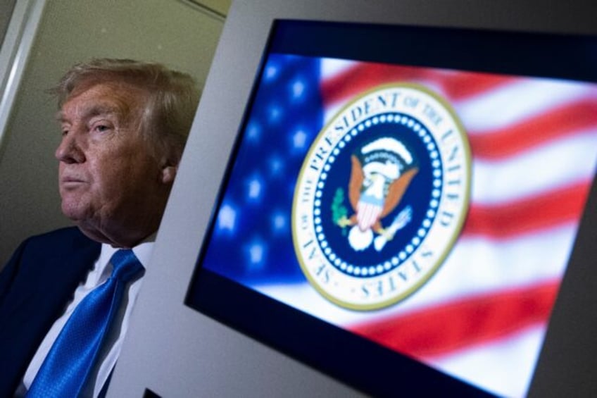 US President Donald Trump speaks to reporters about the G7 Summit aboard Air Force One whi