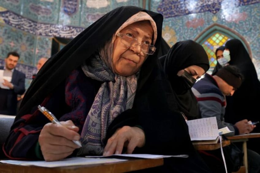 Iranian women fill out their ballots in the election for which local Fars news agency esti