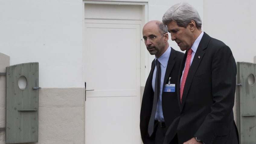 Malley, a controversial Washington figure, walks with former Secretary of State John Kerry.