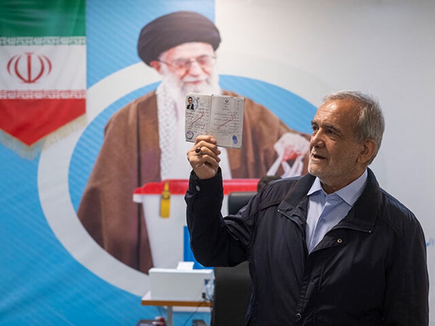 Iranian reformist lawmaker, Masoud Pezeshkian, is holding up his identification while stan