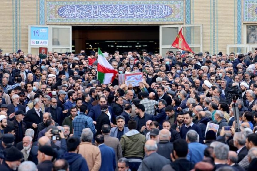 Mourners gather outside a Tehran mosque for the funeral of 89 people killed in twin blasts in the southern city of Kerman claimed by the jihadist Islamic State group