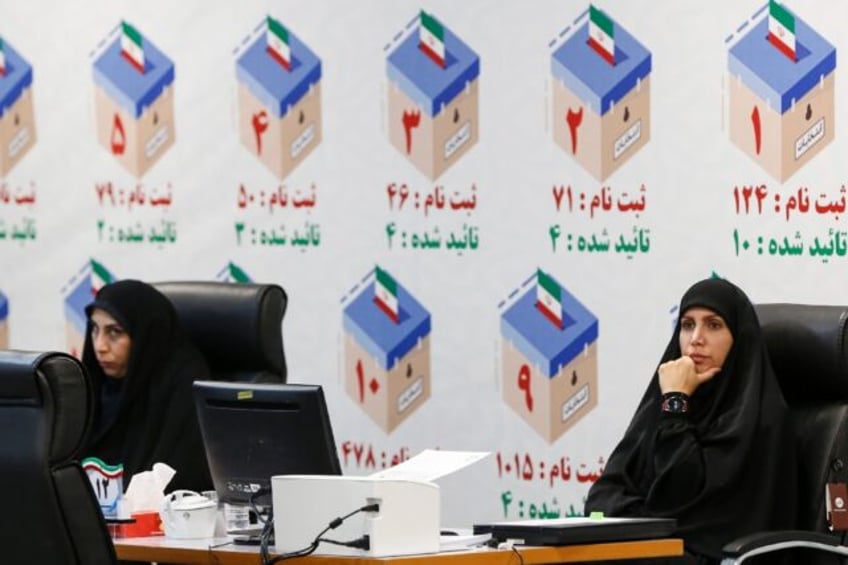 Iranian electoral officials at a registration office in Tehran ahead of snap elections fol