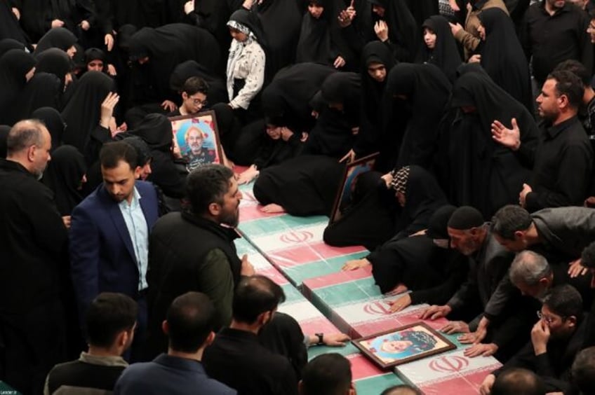 Relatives in Iran mourn over the coffins of seven Revolutionary Guard Corps members killed