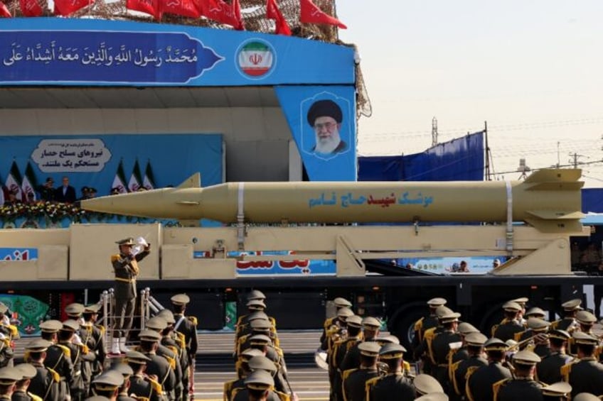 Iran's president looks on, as a 'Qasem Soleimani' missile is displayed during an annual mi