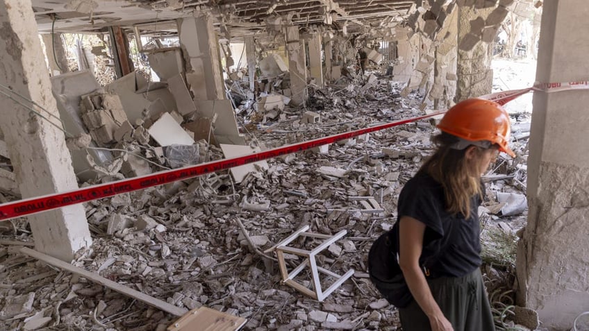 A woman retrieves personal belongings from the rubble of her house after a ballistic missile fired from Iran struck the city yesterday morning on June 23, 2025 in Tel Aviv, Israel. I