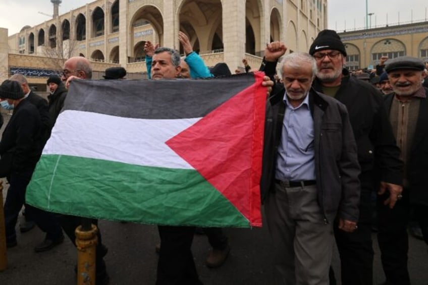 Iranians with a Palestinian flag demonstrate in support of Yemen and Palestinians after Friday prayers in Tehran