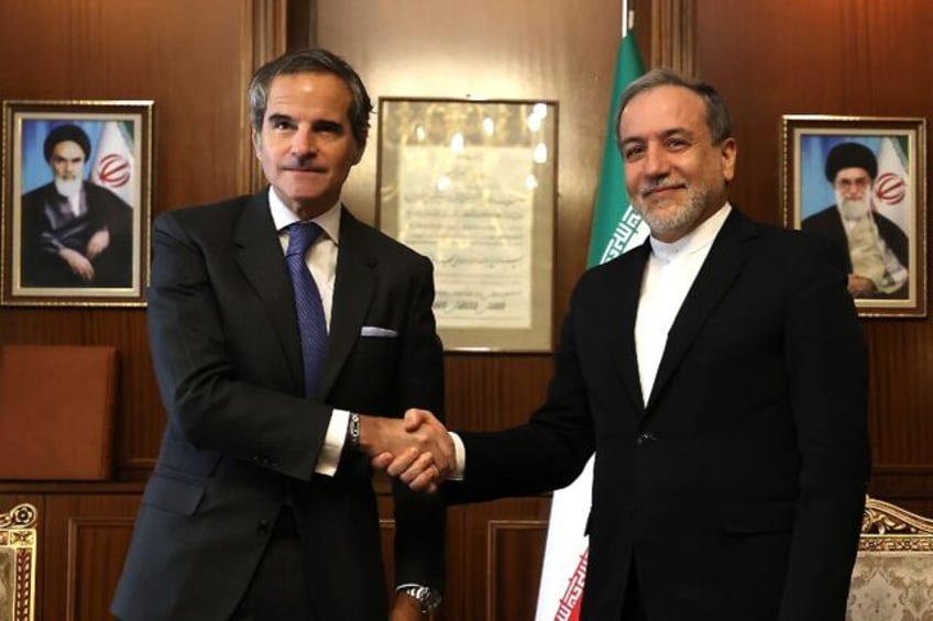 International Atomic Energy Agency chief Rafael Grossi (L) shakes hands with Iranian Forei