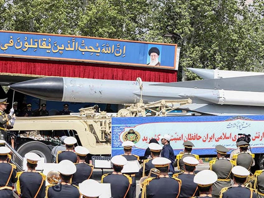 A member of the Iranian armed forces conducts an army orchestra as a truck carries a missile during a military parade as part of a ceremony marking the country's annual army day in Tehran on April 17, 2024. (Photo by ATTA KENARE / AFP) (Photo by ATTA KENARE/AFP via Getty Images)