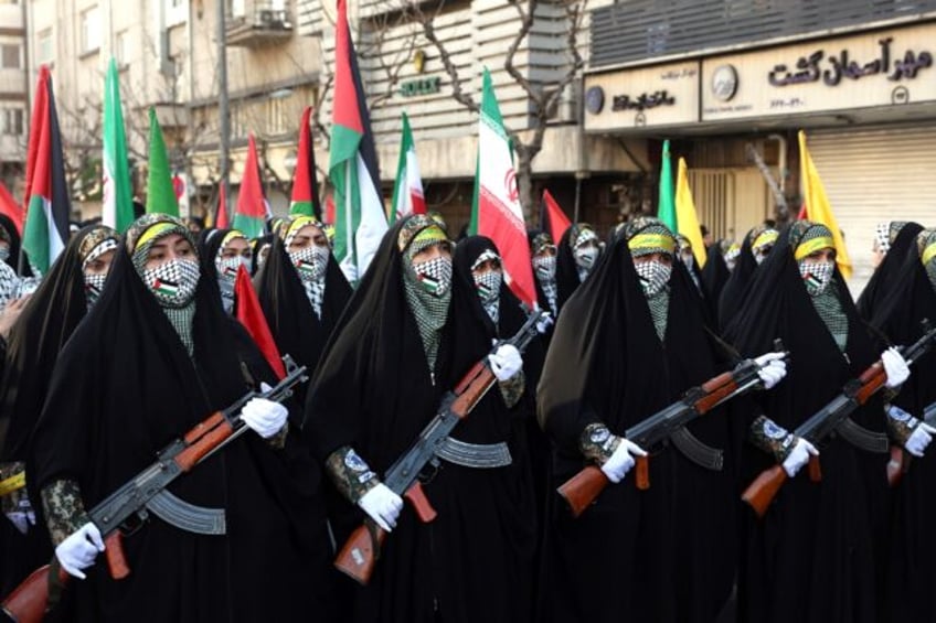 Members of Iranian paramilitary Bassij women's forces march with weapons during the rally