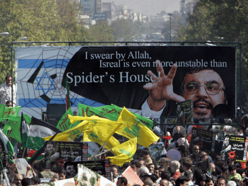 Iranian protestors, holding up a huge banner with the picture of Lebanon's Hezbollah leade