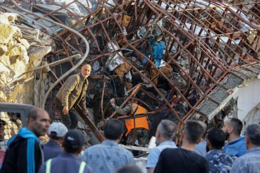 Emergency and security personnel inspect the wreckage of the Iranian consular annex in Dam