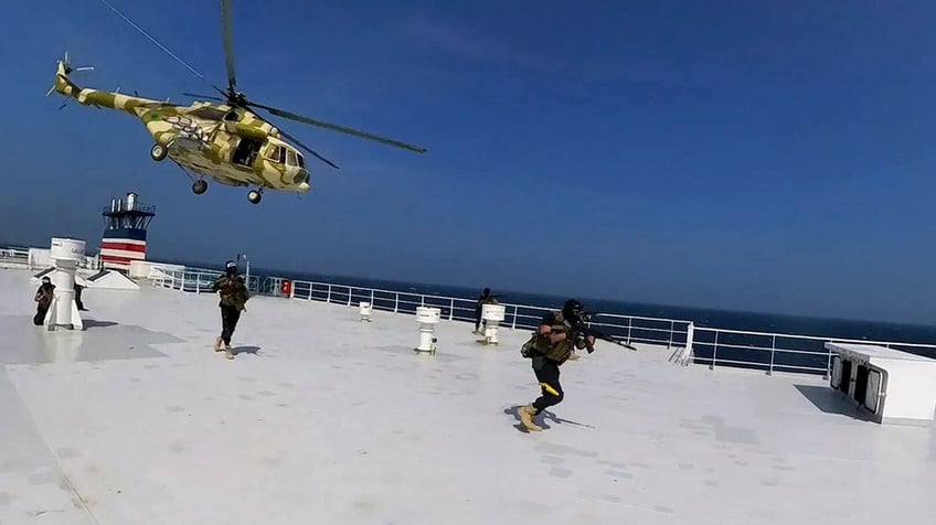 Houthi fighters boarding a cargo ship at sea