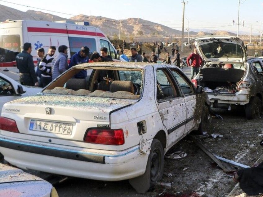 This photograph taken on January 3, 2024 shows destroyed cars and emergency services near the site where two explosions in quick succession struck a crowd marking the anniversary of the 2020 killing of Guards general Qasem Soleimani, near the Saheb al-Zaman Mosque in the southern Iranian city of Kerman. The …