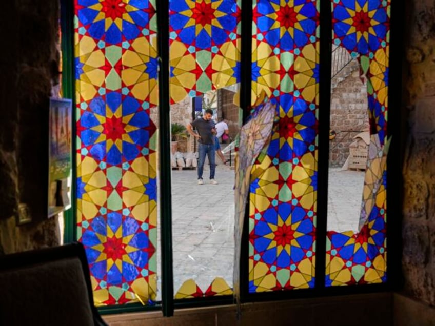 People stand at the courtyard of a partially damaged mosque after a missile launched from