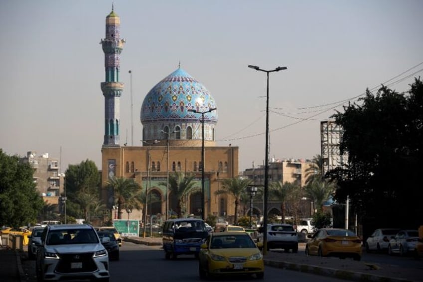 Cars drive past Baghdad's Seventeen Ramadan Mosque on November 19 ahead of Iraq's first ce