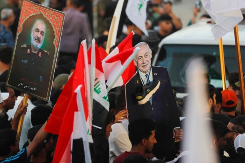 An Iraqi holds a picture of Major General Hossein Salami, head of the Iranian Revolutionar