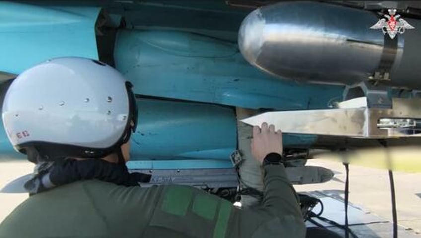 A Russian Su-34 pilot inspects a bomb fitted with a "universal planning and correction module", Russia's equivalent of America's JDAM kit that turns dumb bombs into smart (guided) ones.