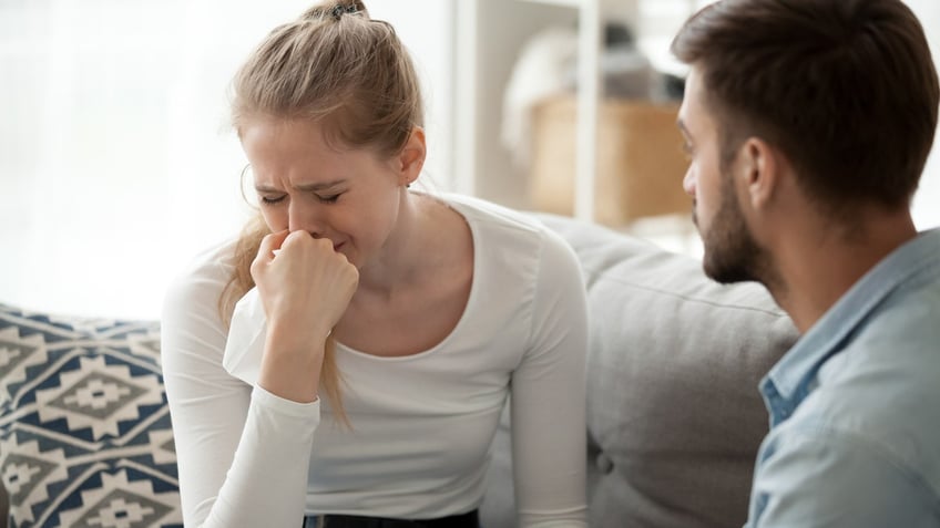 grieving woman supported by man