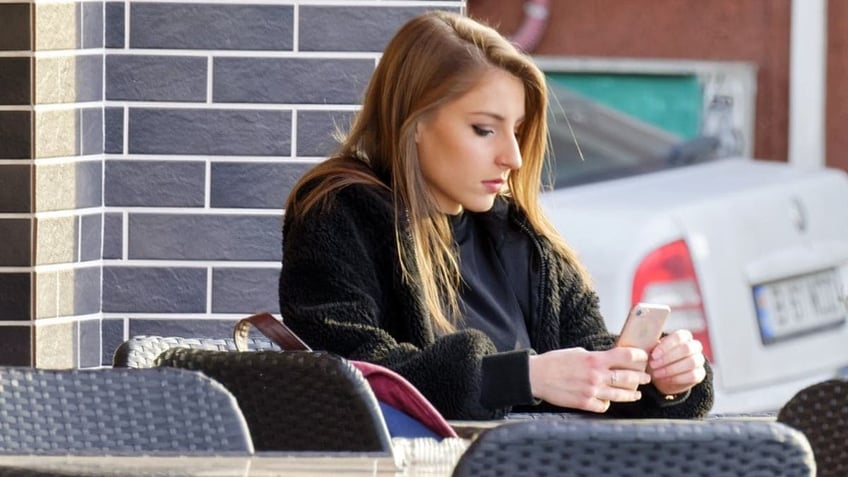 woman looks at phone 