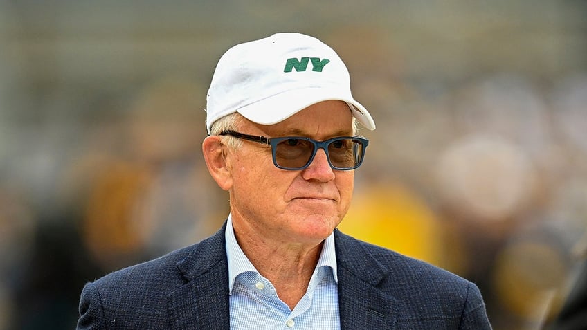 Woody Johnson looks on field