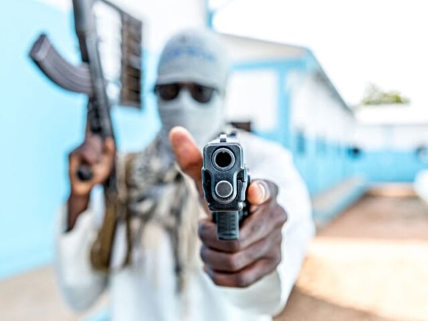 A Togolese policeman, disguised as a terrorist, brandishes his weapon on October 20, 2022