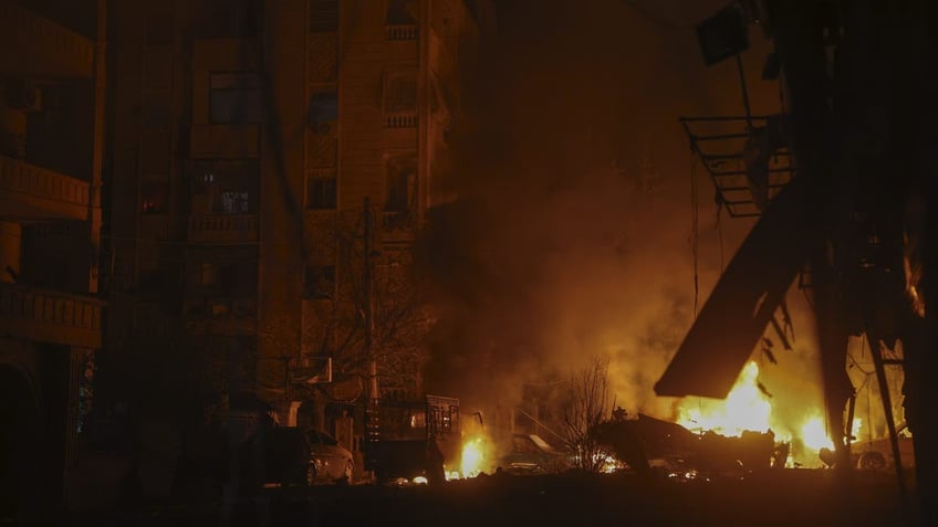 Vehicles burn after an airstrike against opposition fighters in Aleppo, Syria, late Friday, Nov. 29, 2024. 