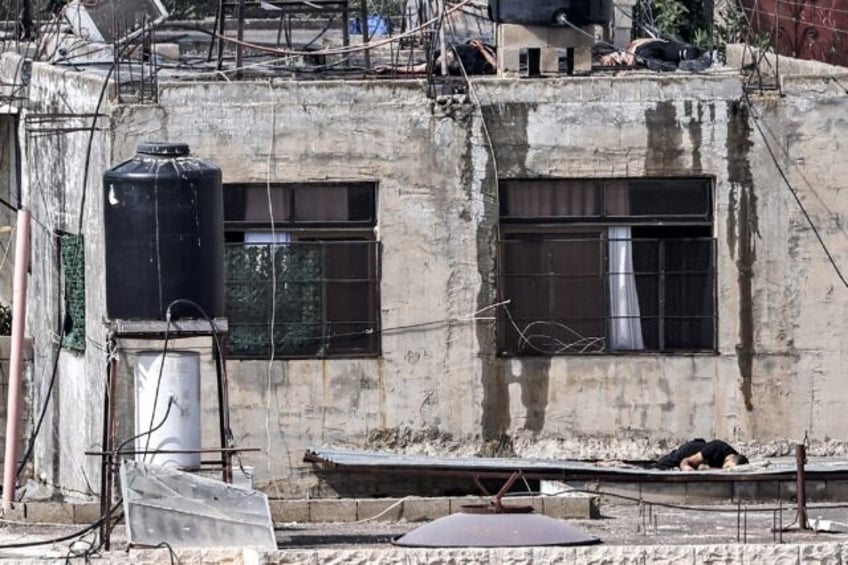 The bodies of three men killed during an Israeli army raid lie on the roof of a building,