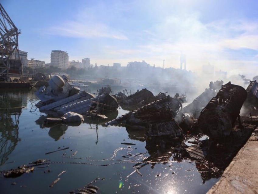 Smoke billows from Syrian naval ships destroyed in an overnight Israeli attack on the port