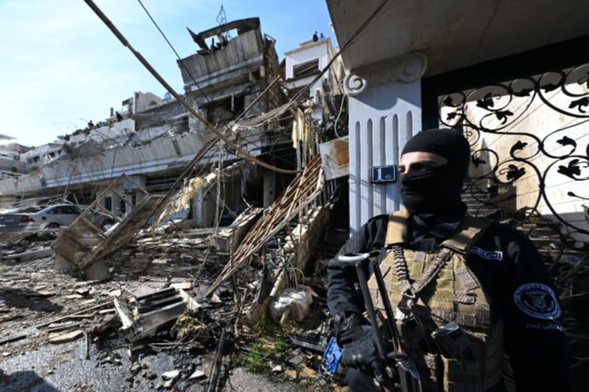 A member of the new Syrian administration's security forces stands guard at the site of an