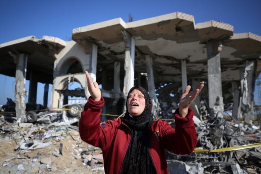 A Palestinian woman reacts in front of a destroyed building in the Al-Maghazi refugee camp in central Gaza