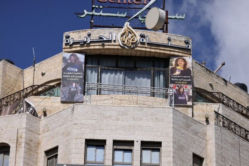 Pictures of slain Al Jazeera journalist Shireen Abu Akleh hang on the channel's office in