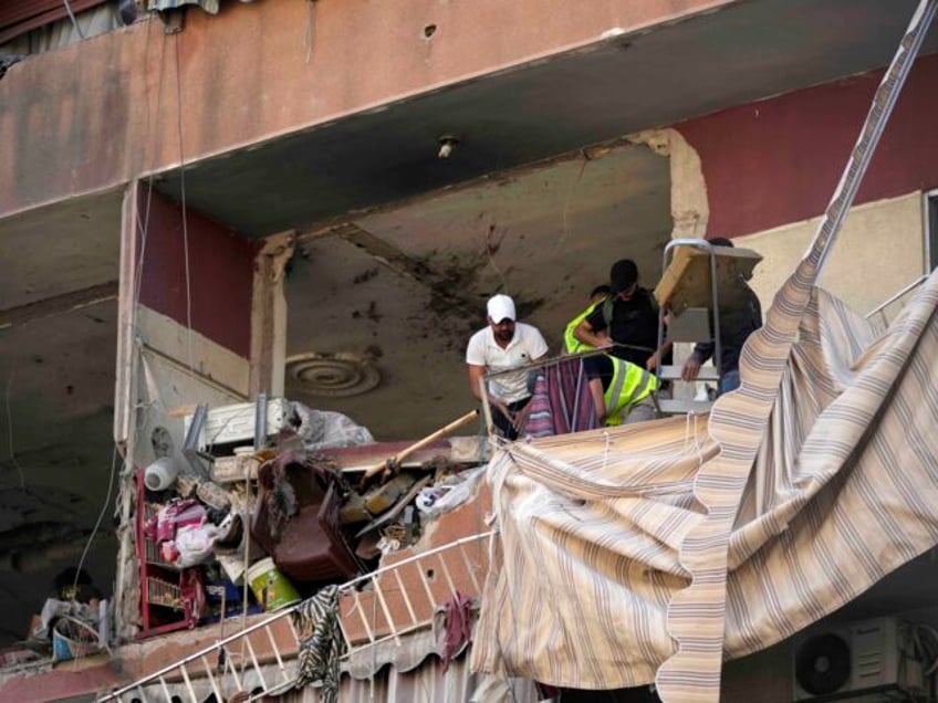 Residents and rescuers check a building that was hit by an Israeli airstrike in Beirut&#03